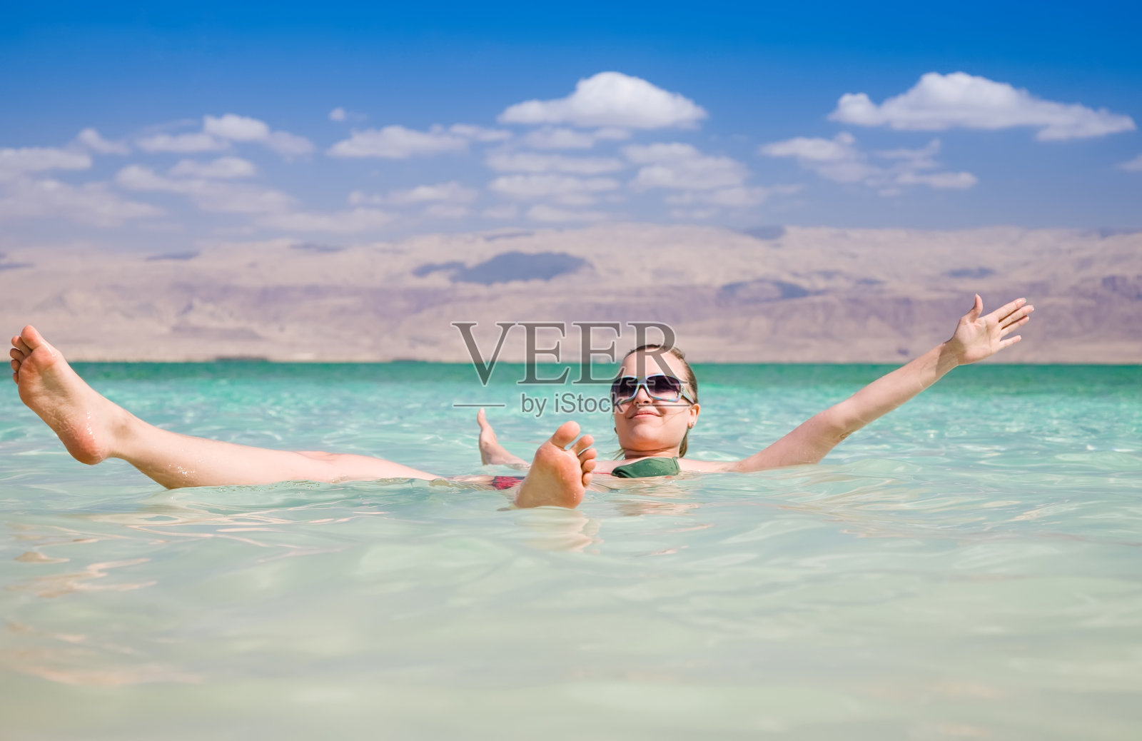 在死海的咸水上漂浮的女人照片摄影图片