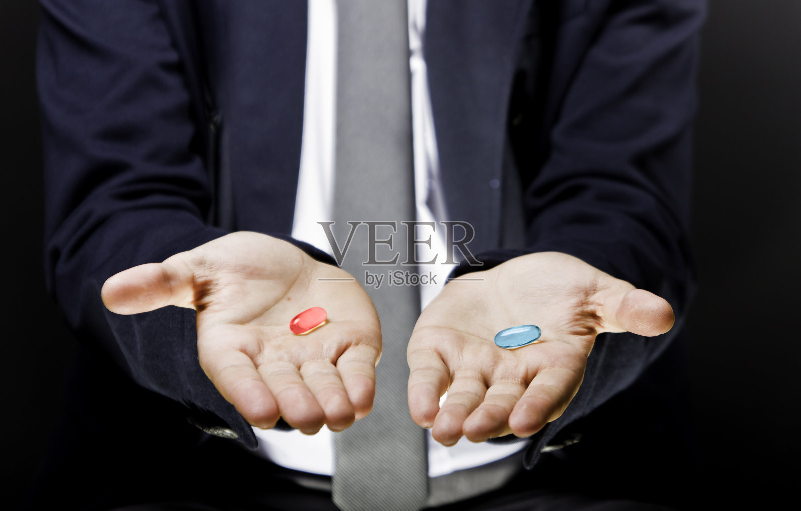 男人的手拿着两个凝胶药丸一个是红色的另一个是蓝色的照片摄影图片