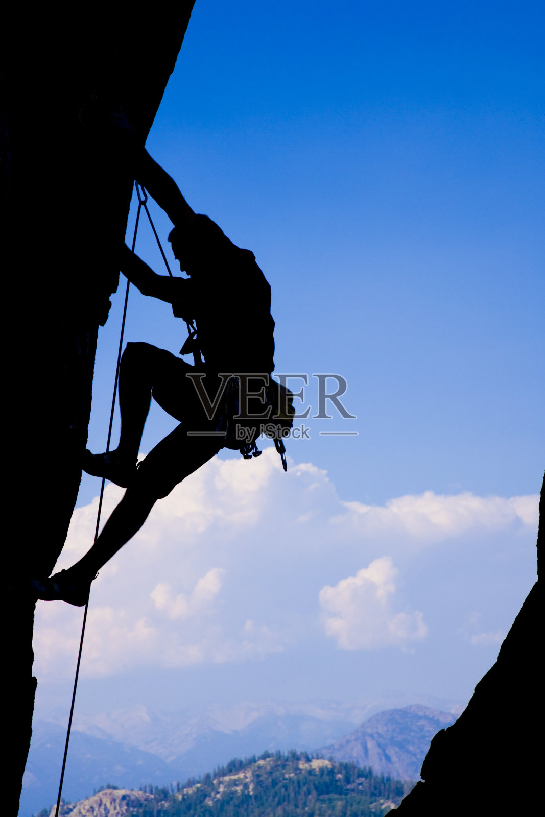 攀岩者紧紧抓住悬崖的剪影照片摄影图片