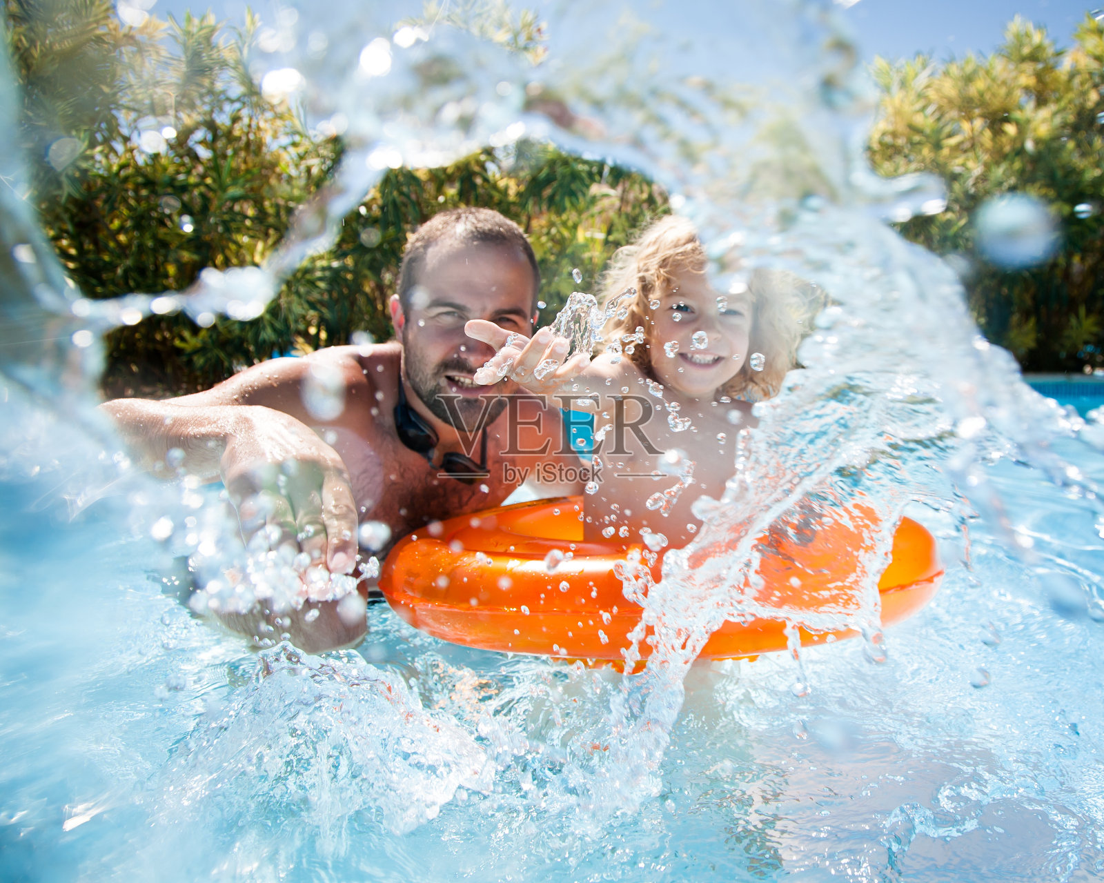 孩子和父亲在游泳池里照片摄影图片