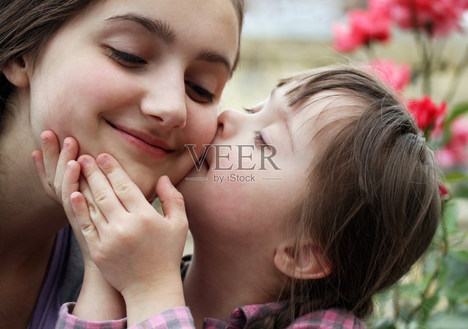 一个小女孩亲吻她母亲的脸颊照片摄影图片