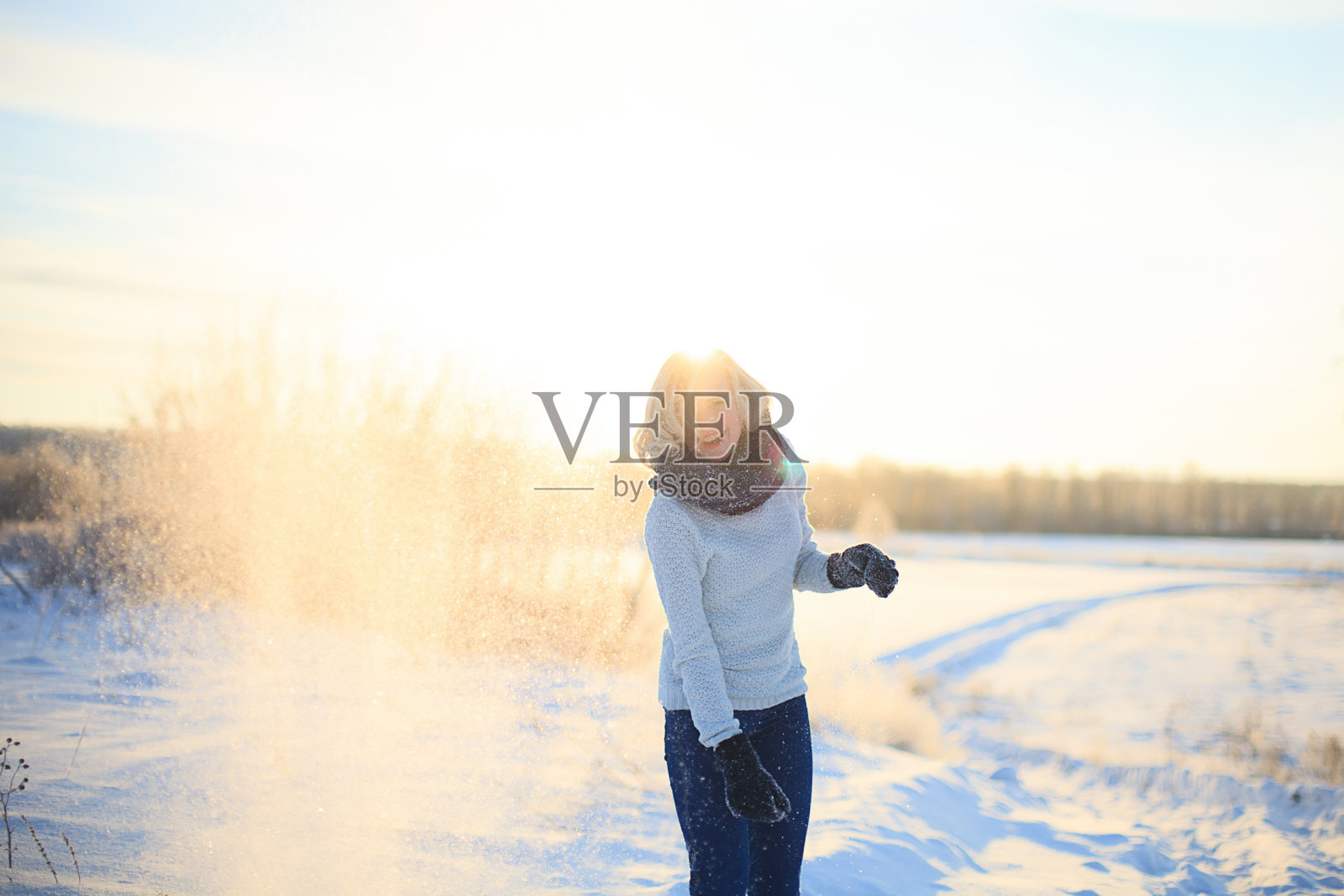 美丽的年轻女孩在冬天玩雪，并高兴。照片摄影图片