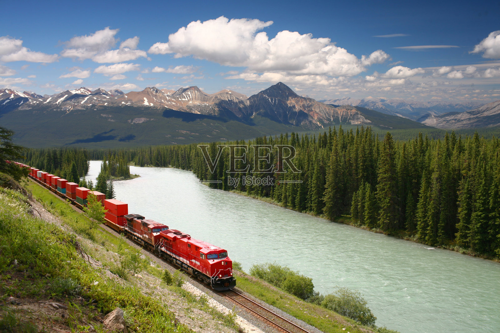 沿着河行驶的货运列车照片摄影图片