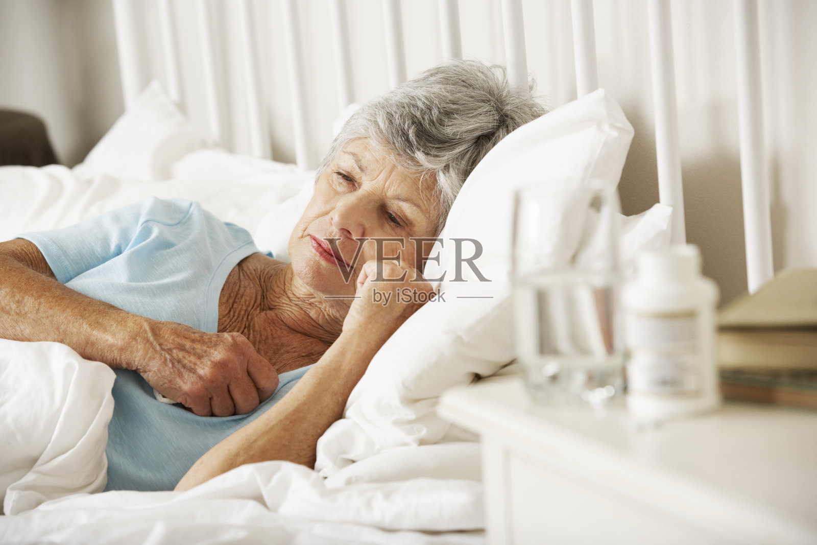 老年失眠妇女床头柜上的药物照片摄影图片
