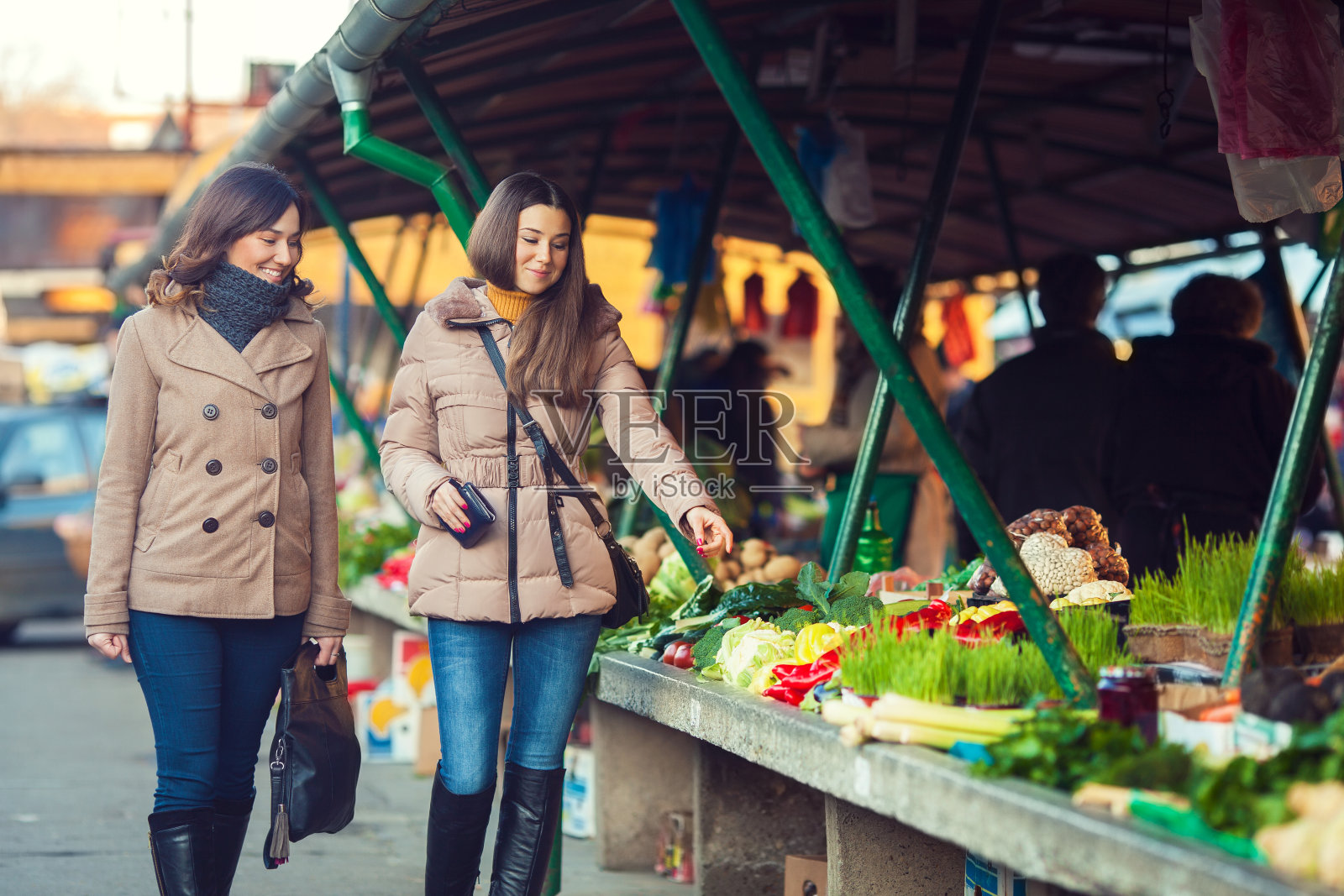 冬日里，两个女人走在农贸市场上照片摄影图片