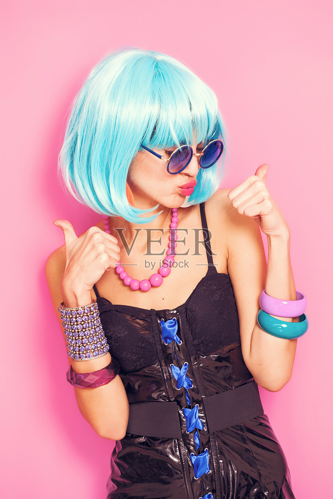 很酷的流行女孩肖像，拇指向上戴着蓝色假发照片摄影图片