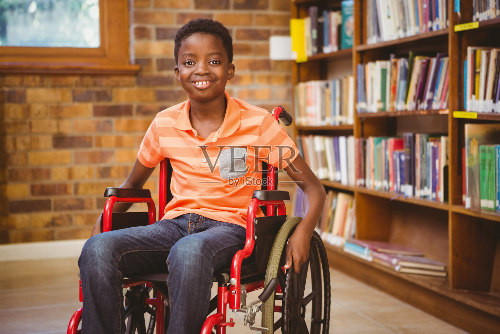 一个男孩坐在图书馆的轮椅上照片摄影图片