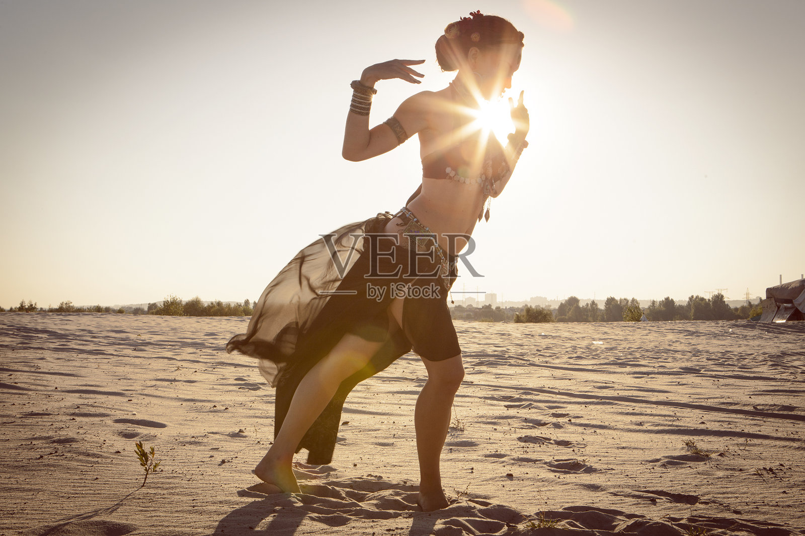 美丽的女孩在沙漠中跳民族舞蹈照片摄影图片