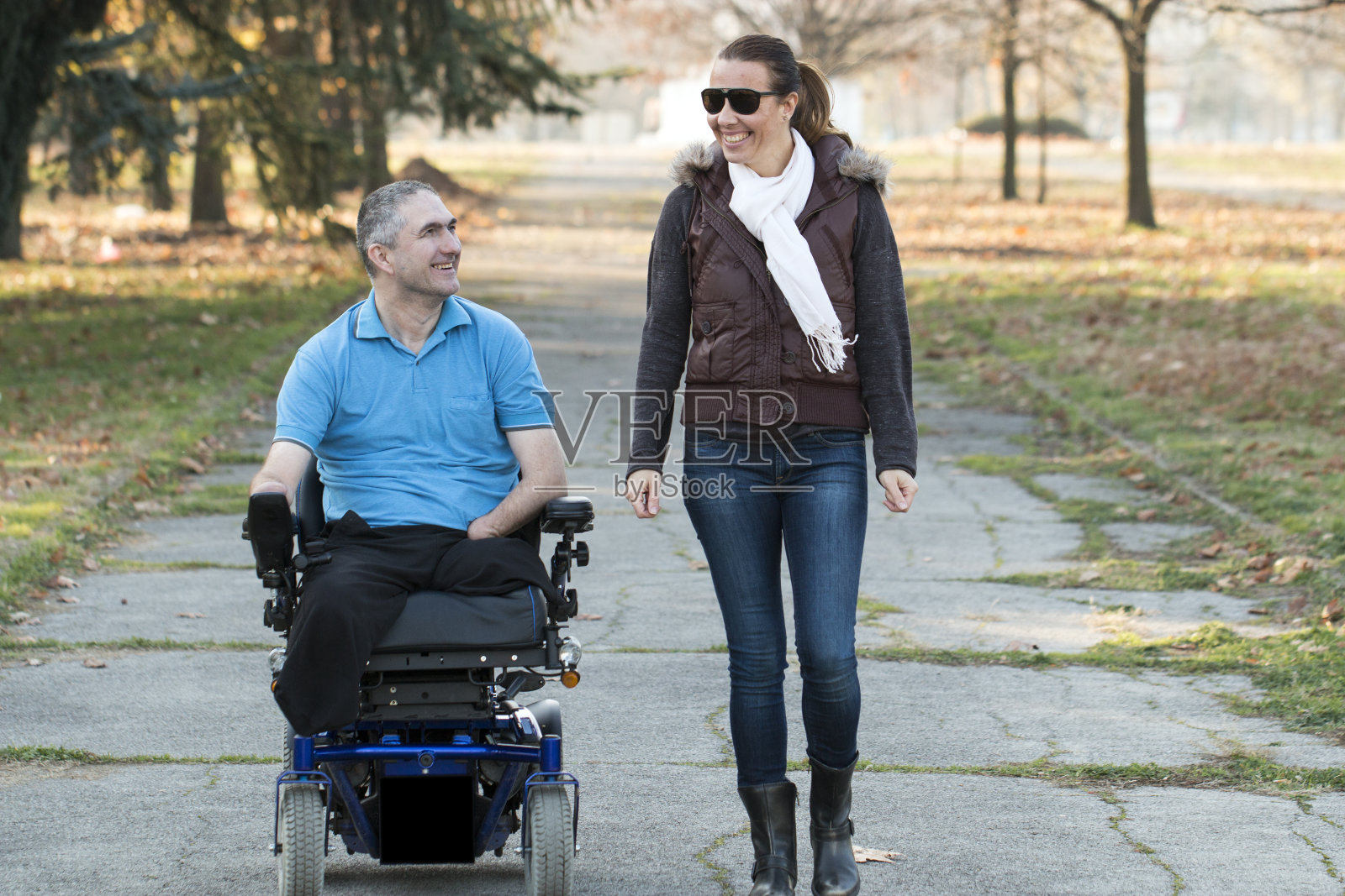 一个坐电动轮椅的人和朋友在一起照片摄影图片