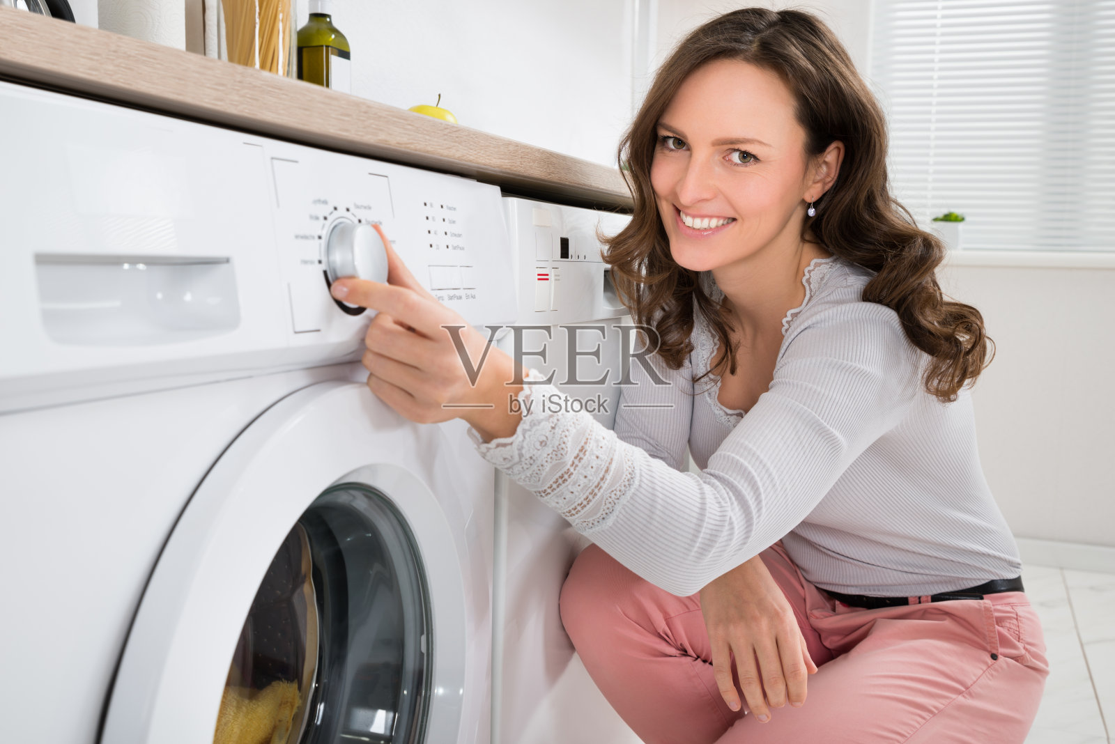 按洗衣机按钮的女人照片摄影图片