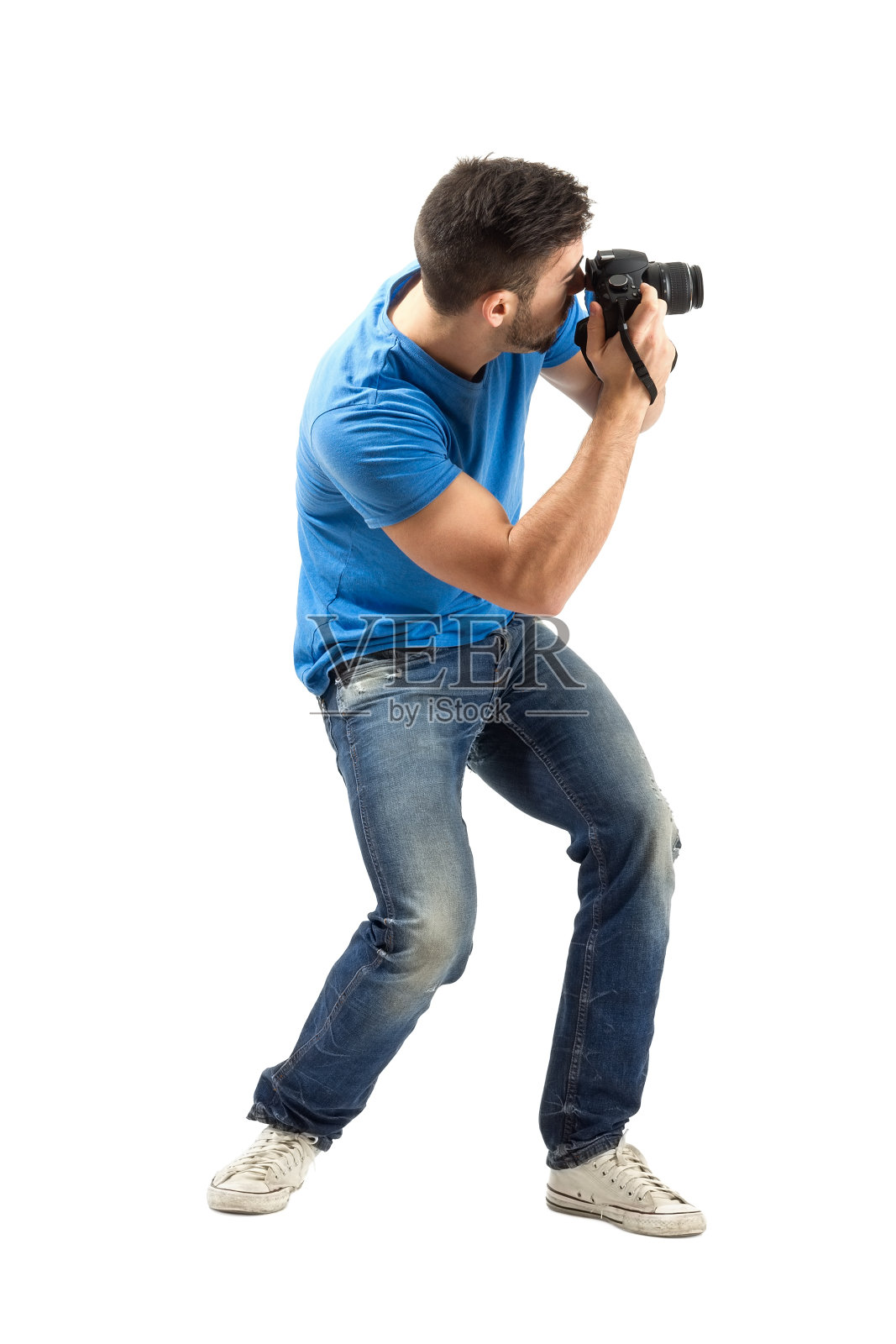弯腰年轻人正在用数码相机拍摄侧视图照片摄影图片