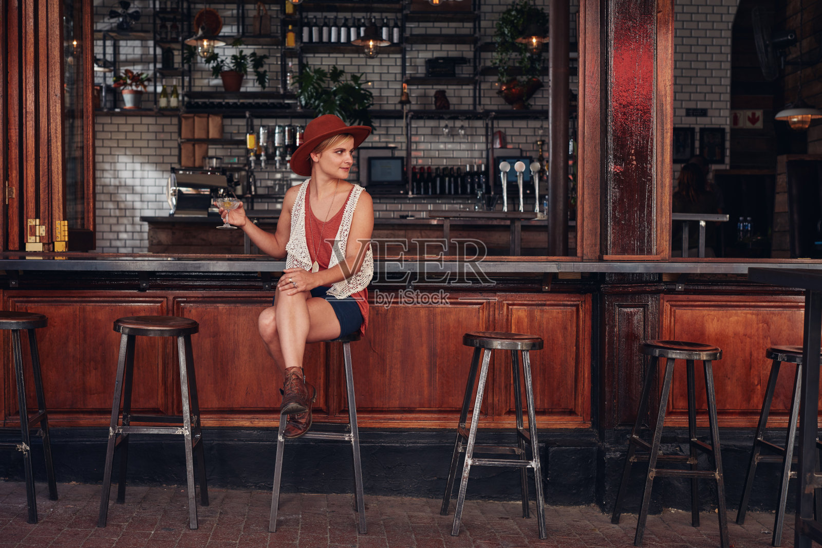 时尚的年轻女性坐在咖啡馆喝饮料照片摄影图片