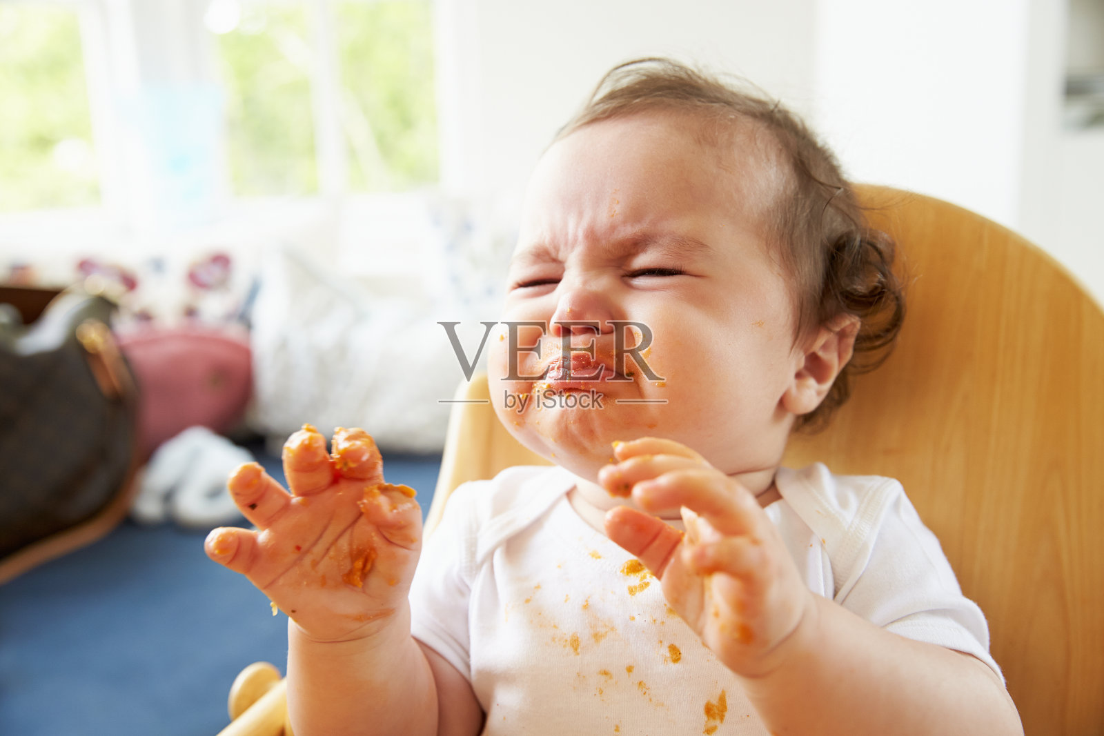 不开心的婴儿在高椅子上用餐时间照片摄影图片
