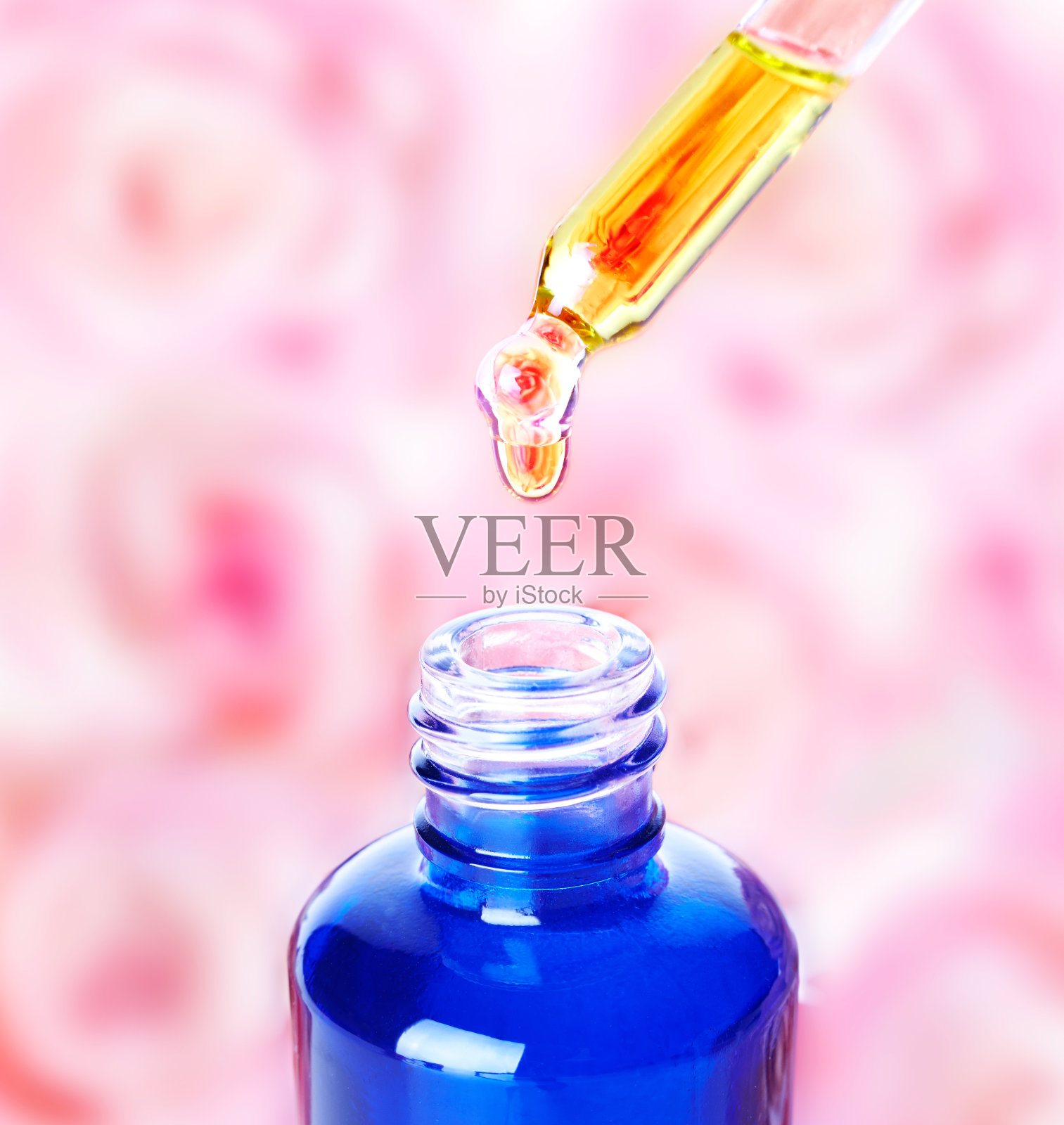 玫瑰精油从吸液管滴入瓶中。芳香疗法。照片摄影图片