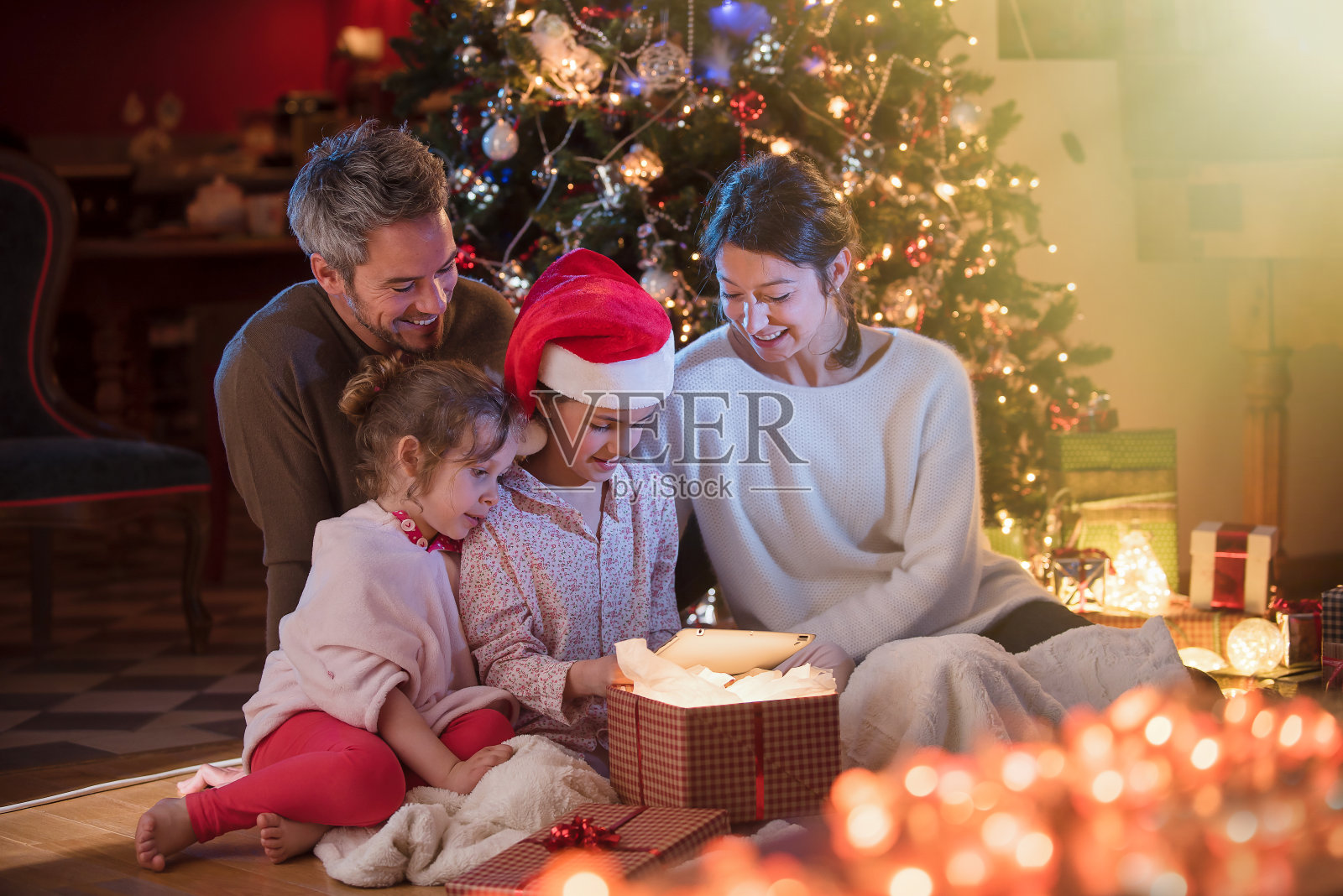 圣诞节时，一个家庭在他们的礼物里发现了一块平板电脑照片摄影图片