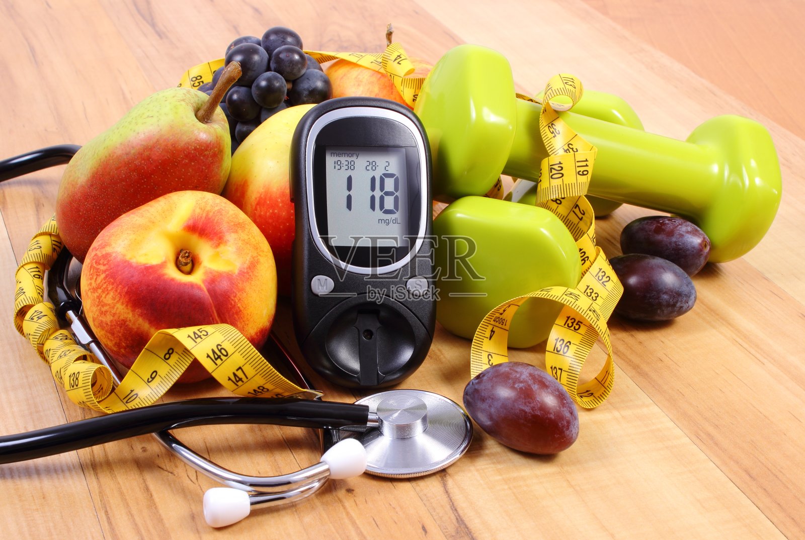 葡萄糖计与医疗听诊器，水果和哑铃照片摄影图片