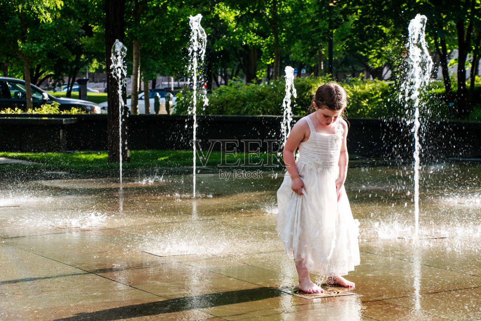 小女孩在喷泉里玩耍照片摄影图片