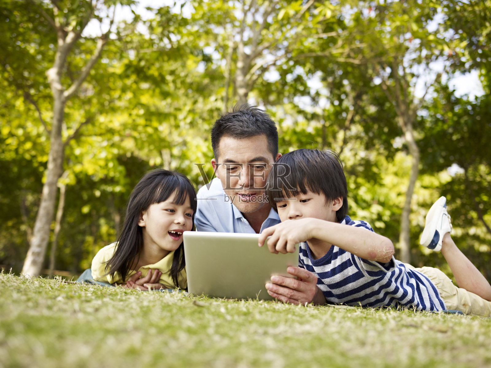 亚洲父亲和孩子在户外使用平板电脑照片摄影图片