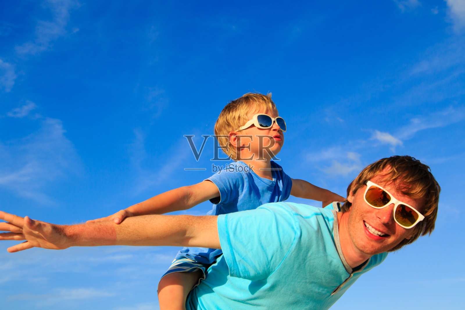 父亲和儿子在夏天的蓝天上玩耍照片摄影图片