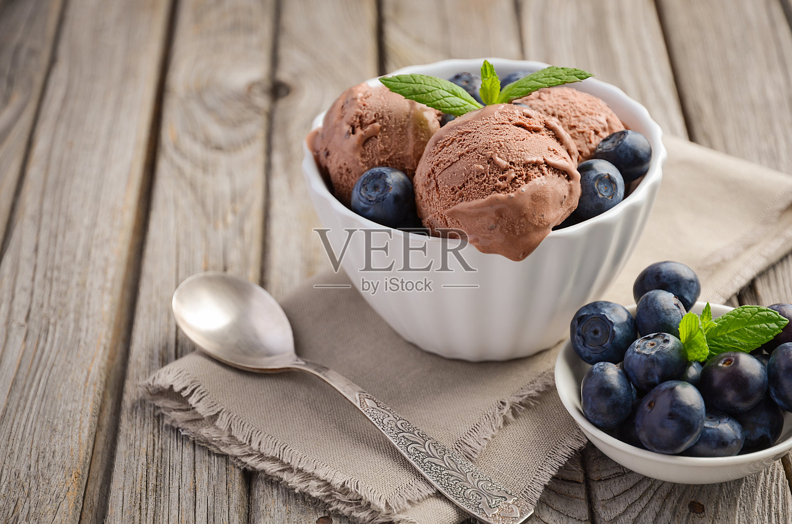巧克力冰淇淋与蓝莓在白色碗在乡村木制背景照片摄影图片