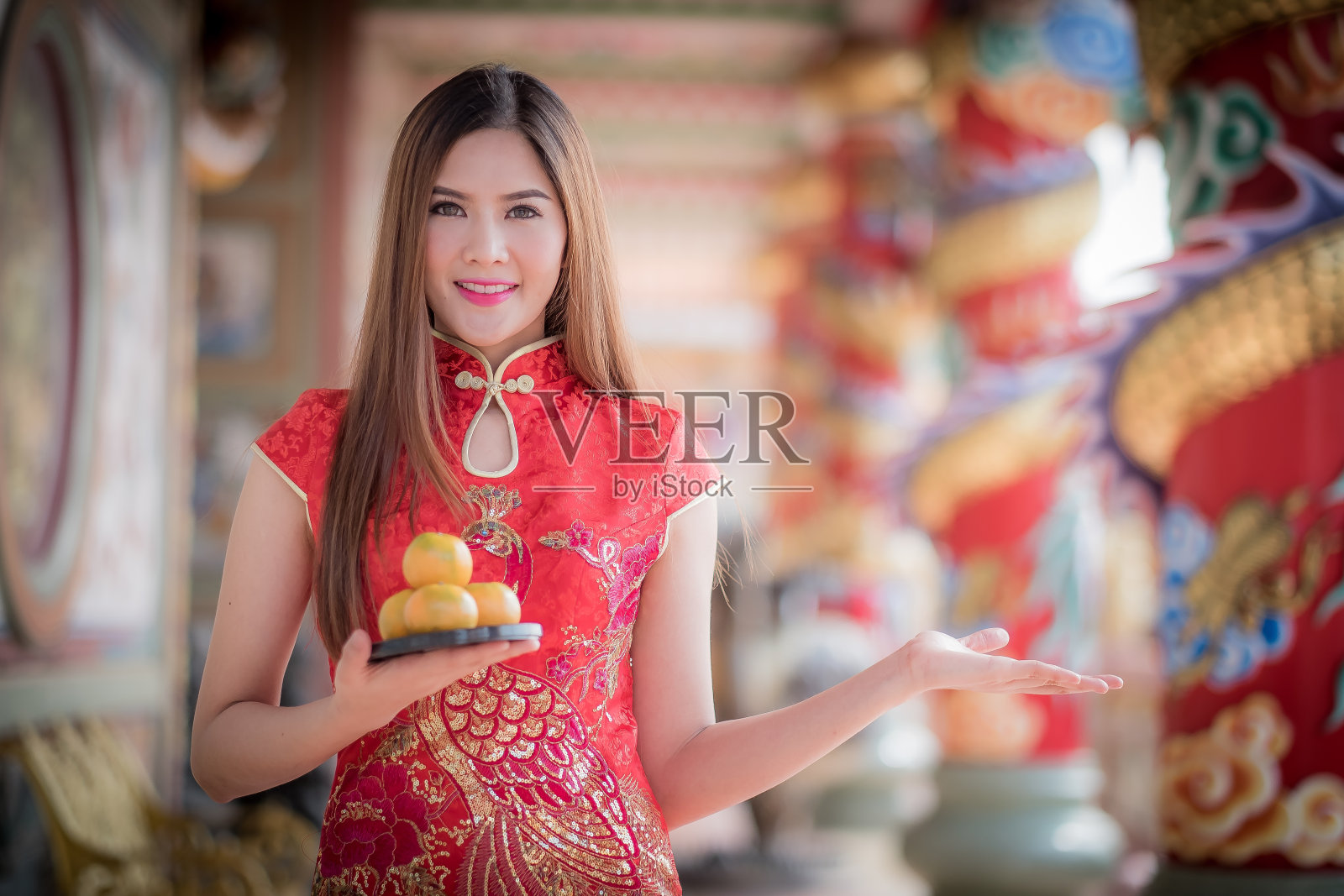 身穿传统中式服装的亚洲华人女子，手里拿着橙色的pa照片摄影图片