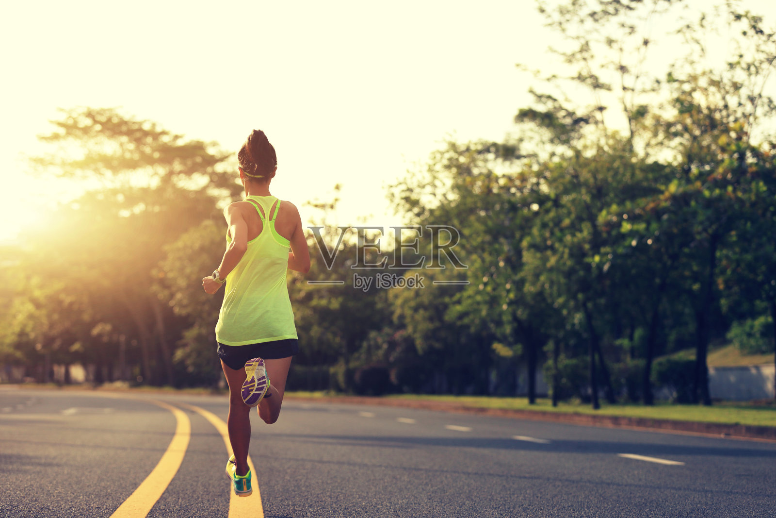 年轻的健身女运动员在公路上跑步照片摄影图片