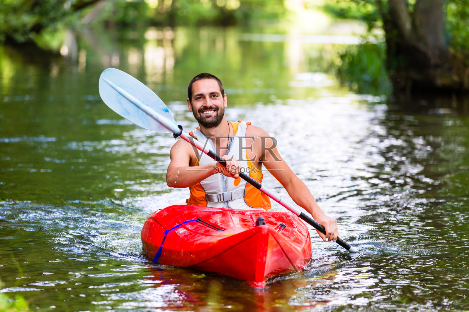 在森林河上驾驶皮划艇的男子照片摄影图片