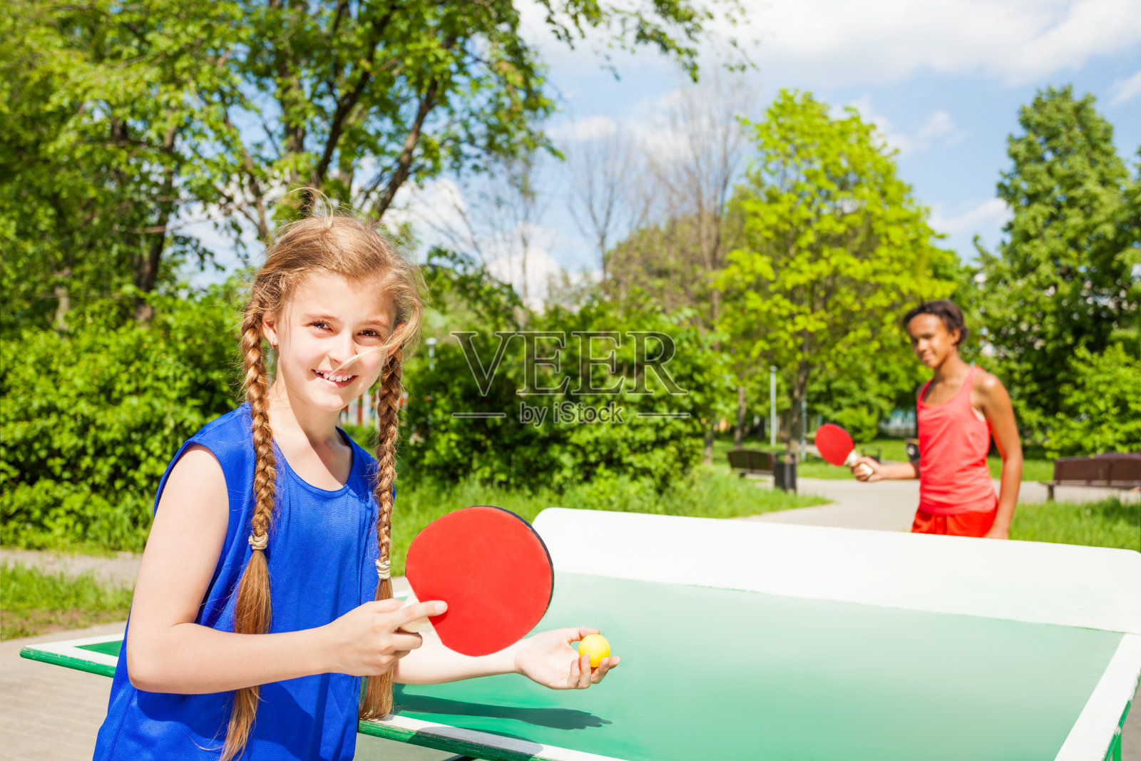 两个快乐的女孩在外面打乒乓球照片摄影图片