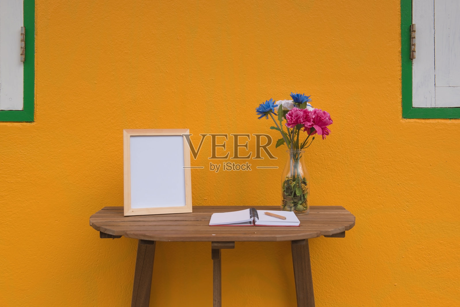 木桌上的相框，黄色背景照片摄影图片