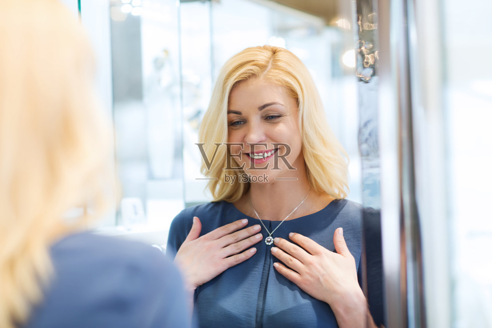 在珠宝店挑选吊坠的快乐女人照片摄影图片
