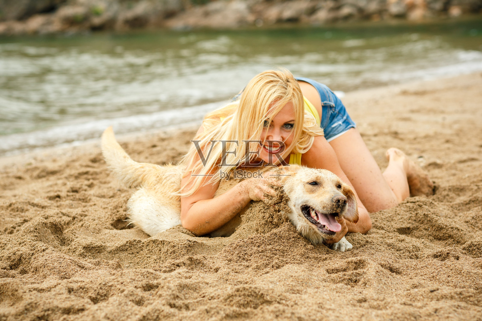 一个女人和一只狗在沙滩上玩耍照片摄影图片