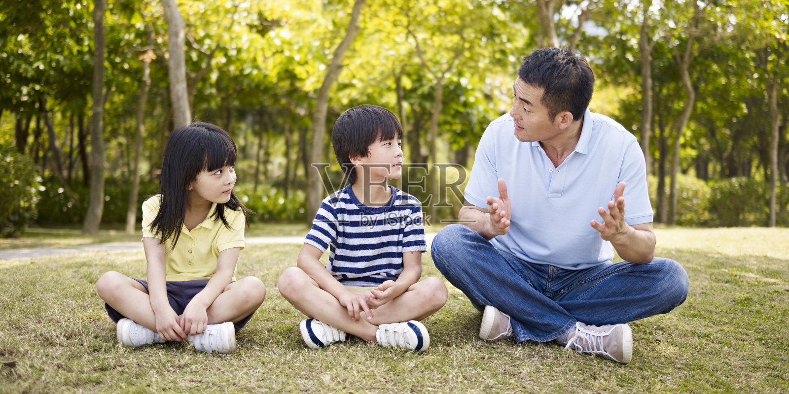 亚裔父亲和孩子们在公园里聊天照片摄影图片