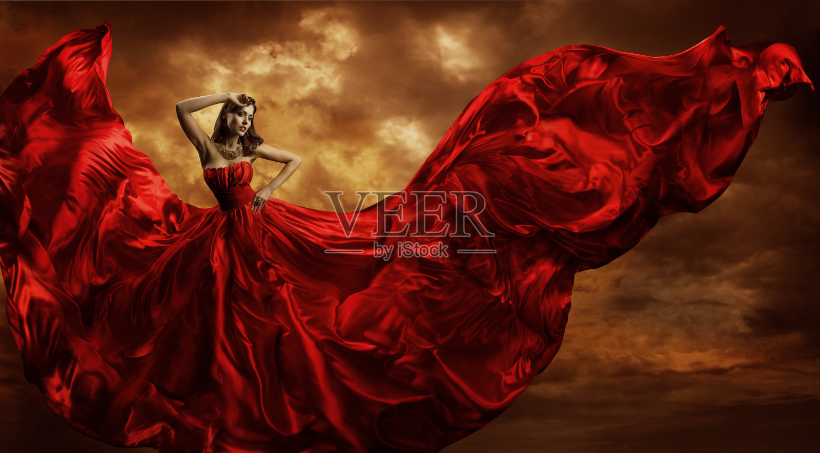 女人红裙飞舞的丝绸面料，时装模特舞风照片摄影图片