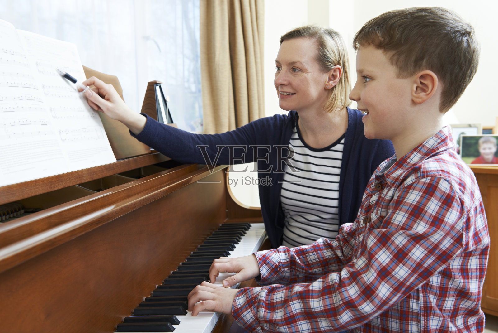 男孩和音乐老师正在上钢琴课照片摄影图片
