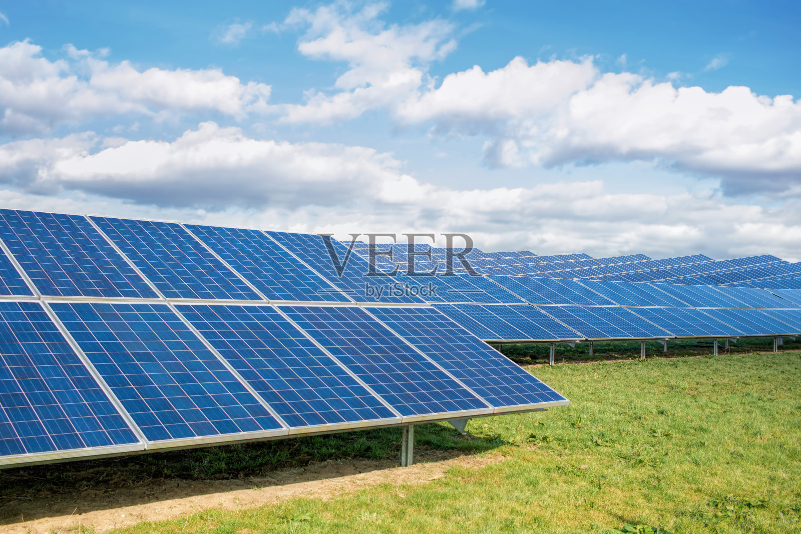 太阳能农场。绿色田野，蓝天，可持续的可再生能源。照片摄影图片