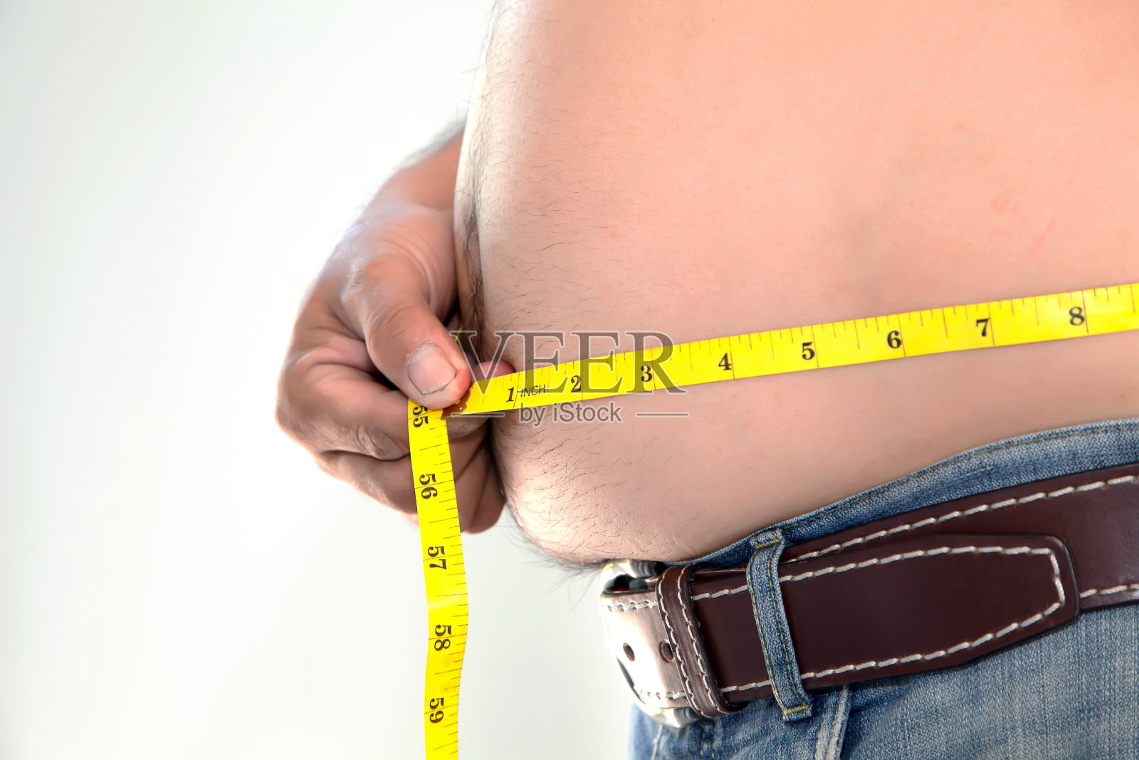 肥胖的人在测量他的肚子。照片摄影图片