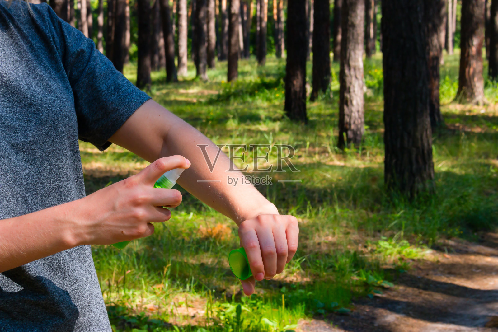 森林里的女孩用喷雾剂对付蚊子照片摄影图片