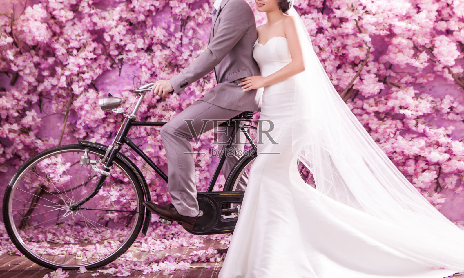 体贴的新娘和骑自行车的新郎站在一起照片摄影图片