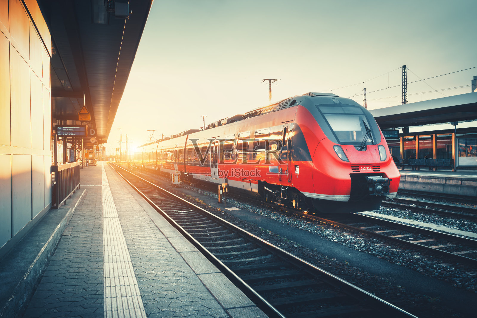 火车站有美丽的现代红色通勤列车在太阳照片摄影图片