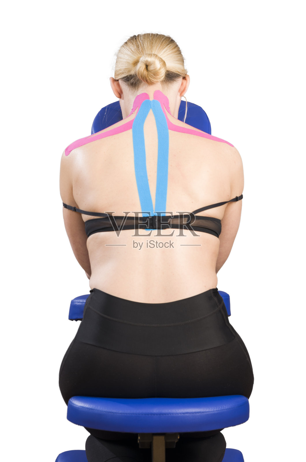 病人在按摩椅上用粉红色和蓝色的肌内肌贴。照片摄影图片