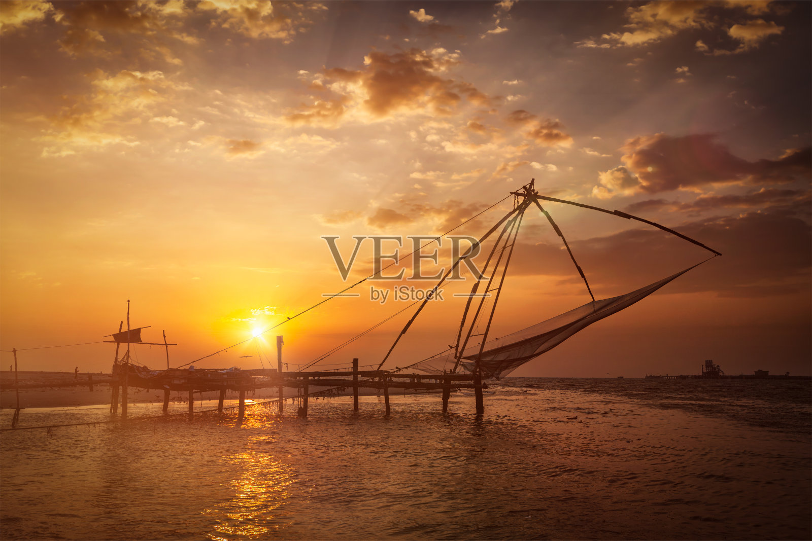 日落时的中国渔网。高知县,喀拉拉邦,印度照片摄影图片