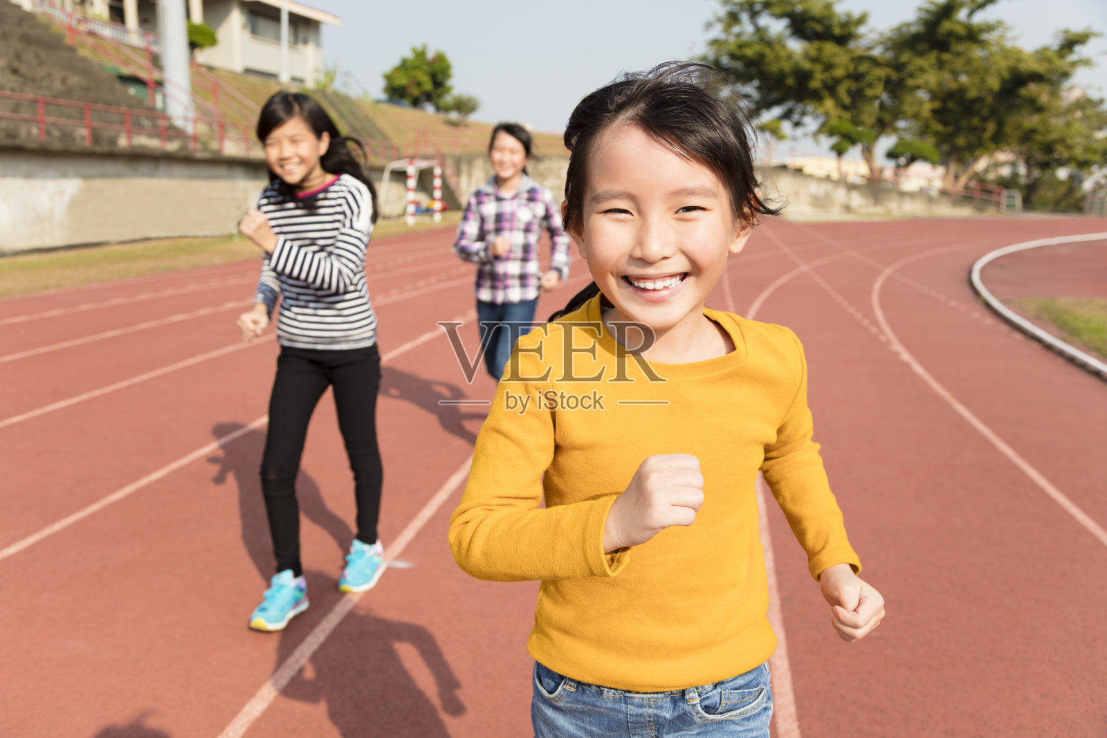 快乐的小女孩在跑道上奔跑照片摄影图片