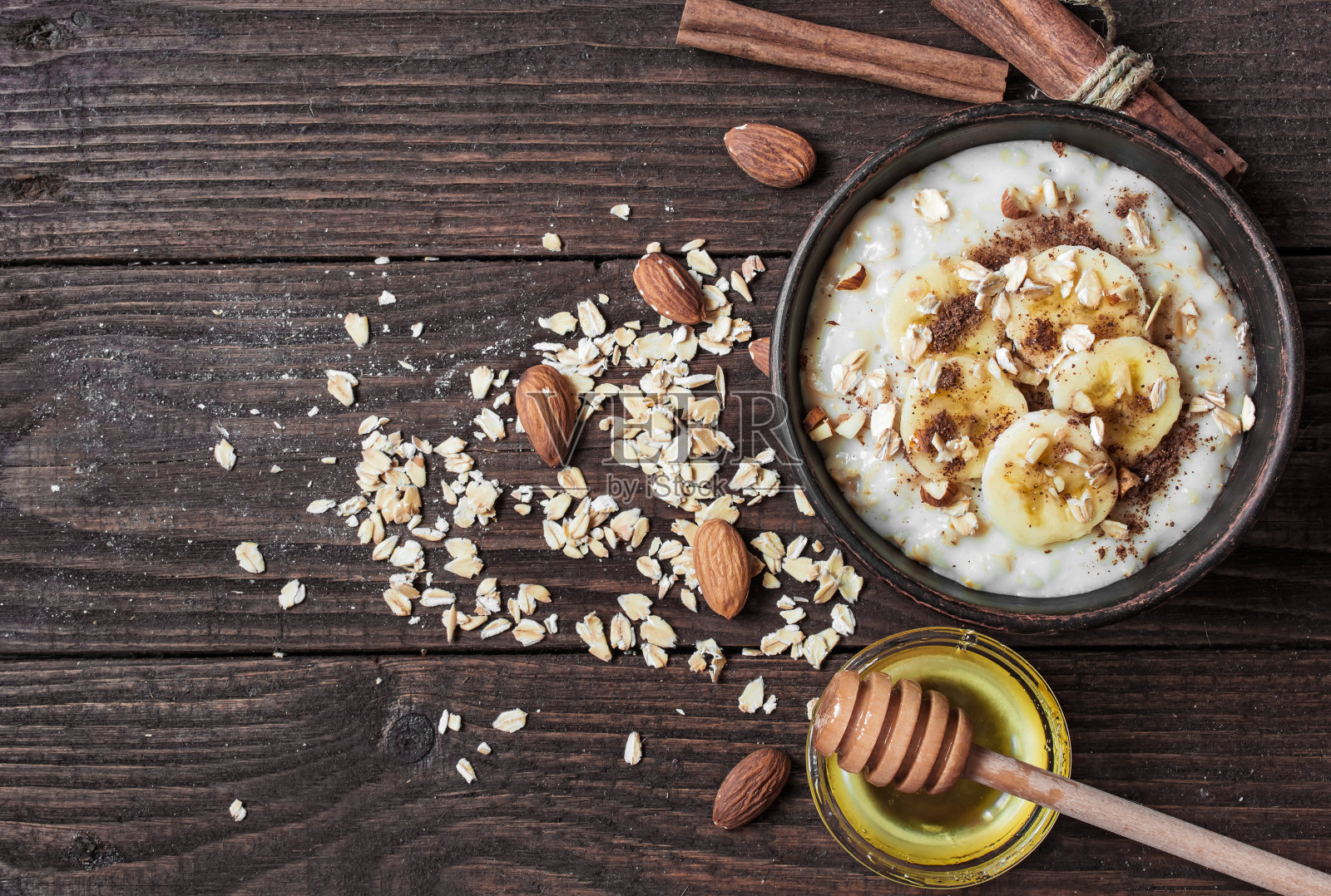 健康的自制燕麦粥，搭配坚果、香蕉、肉桂和蜂蜜照片摄影图片