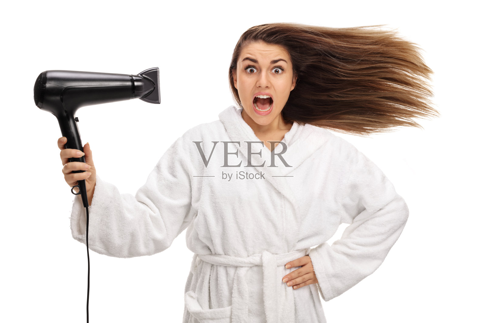 震惊的女人穿着浴袍用吹风机吹干她的头发照片摄影图片
