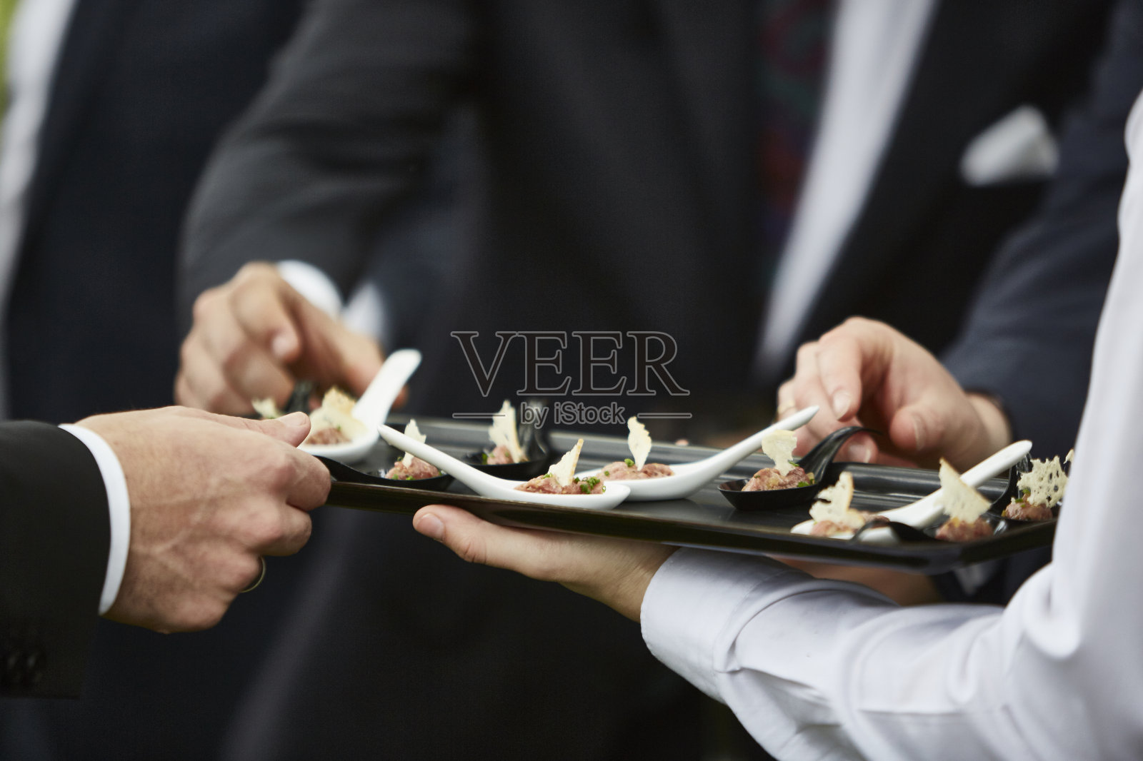 男人的手拿美食的开胃菜由专业的服务员服务照片摄影图片