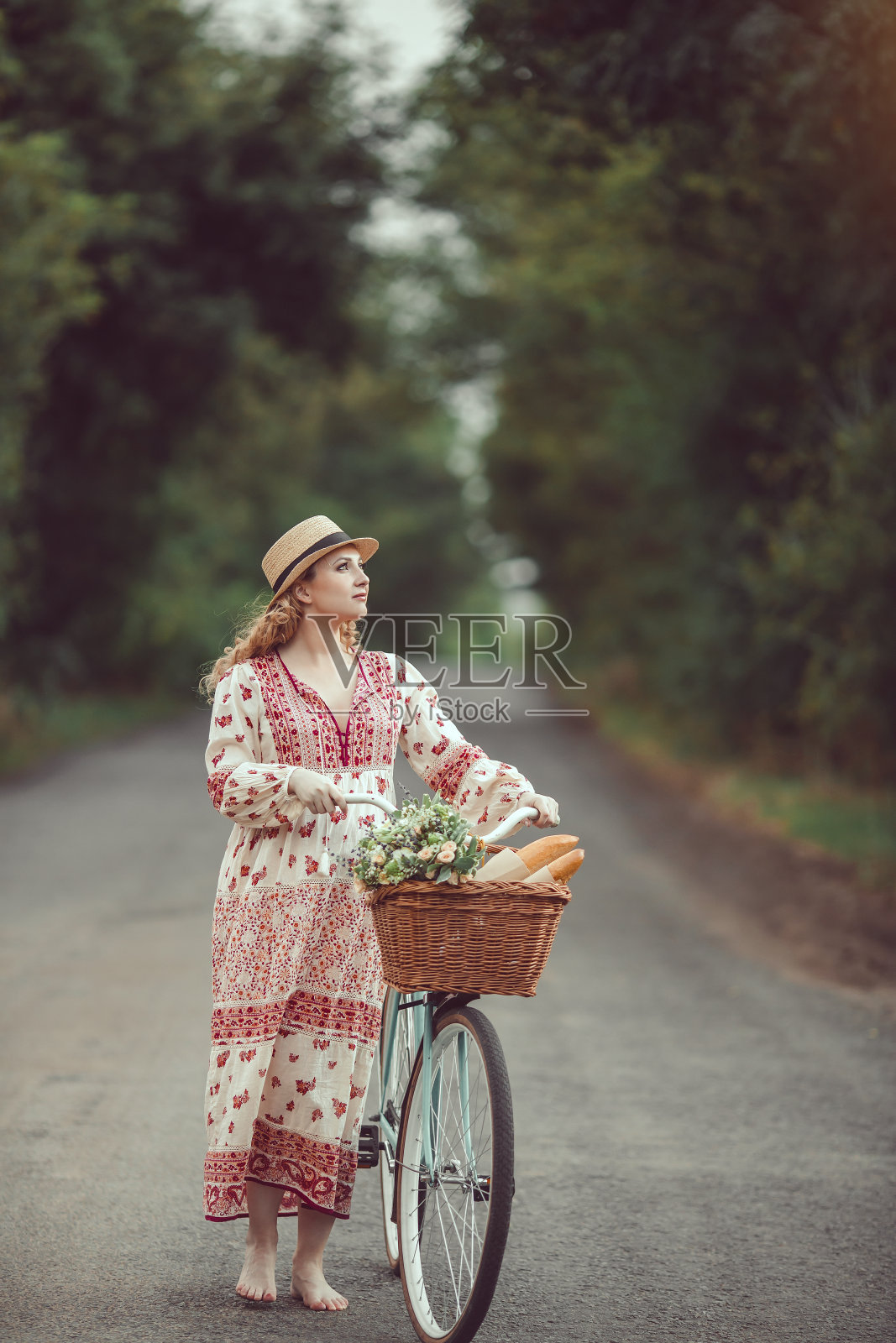 怀孕女孩复古的法国风格与自行车在森林道路上照片摄影图片