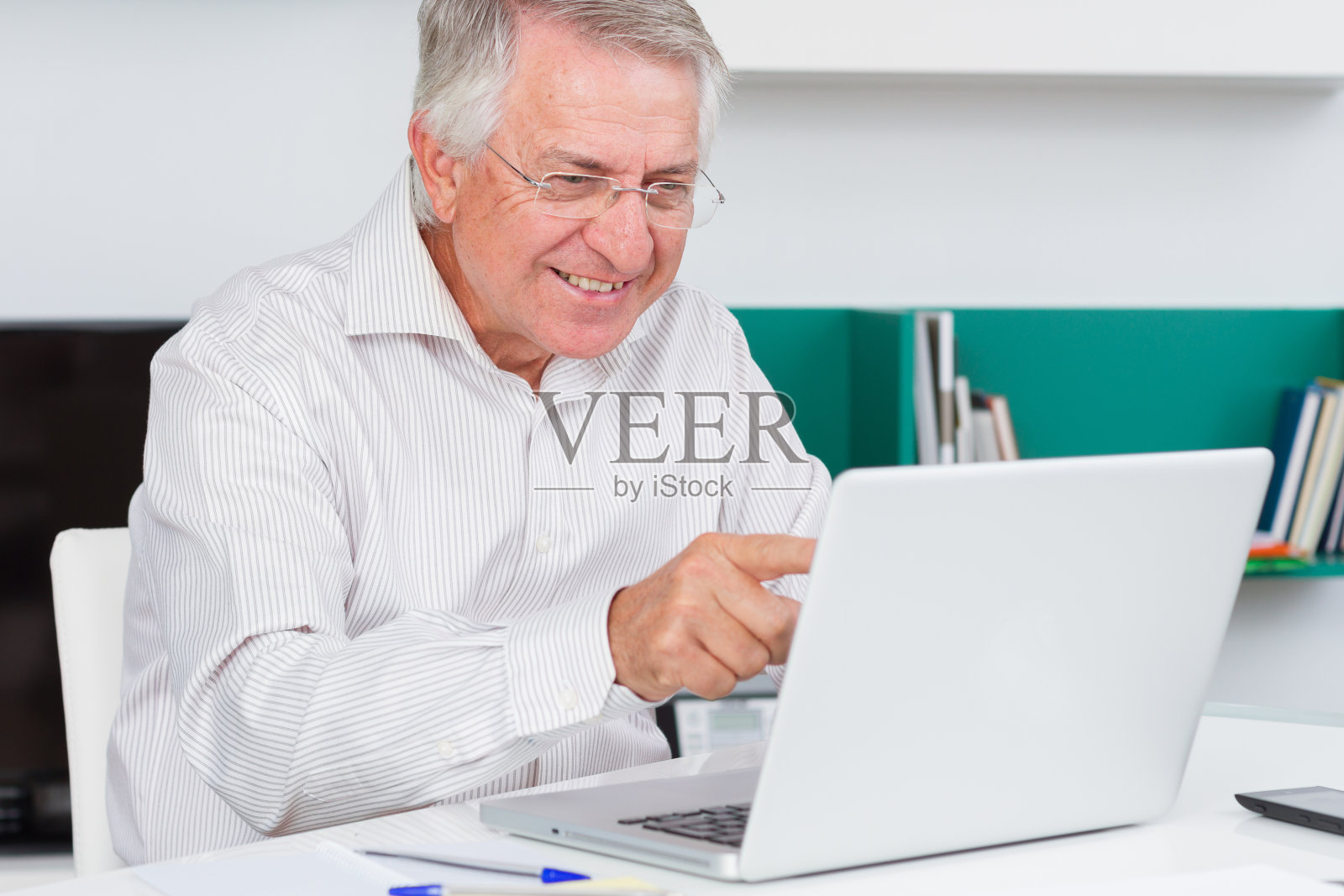 一个成熟的男人在她的笔记本电脑屏幕上看起来很惊讶照片摄影图片