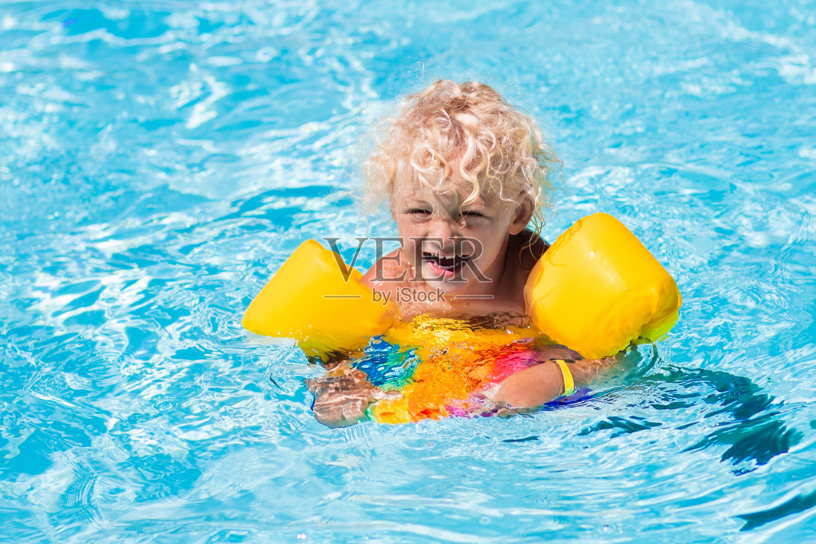 快乐的小男孩在游泳池里照片摄影图片