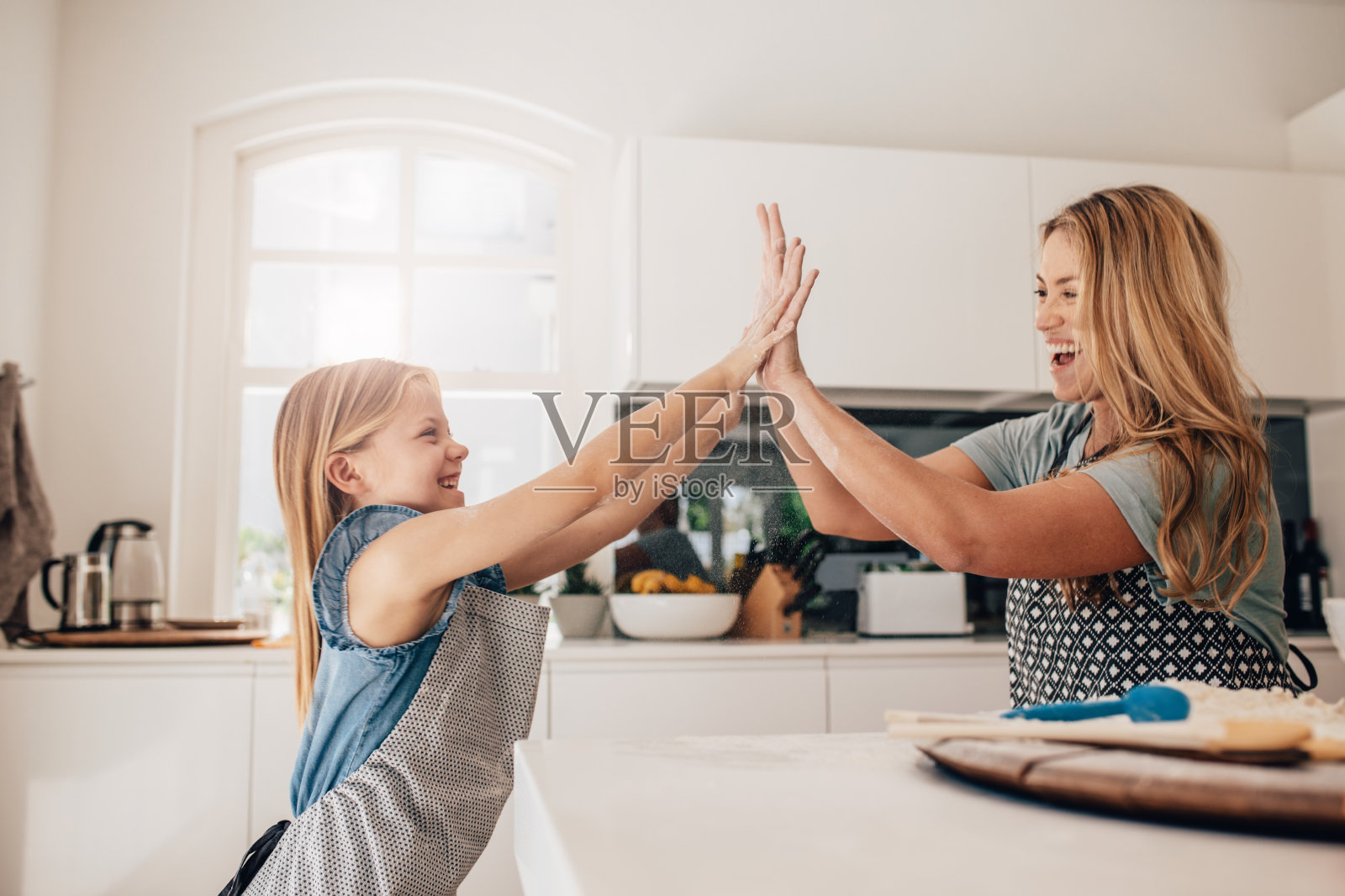 小女孩和她妈妈在厨房里击掌照片摄影图片