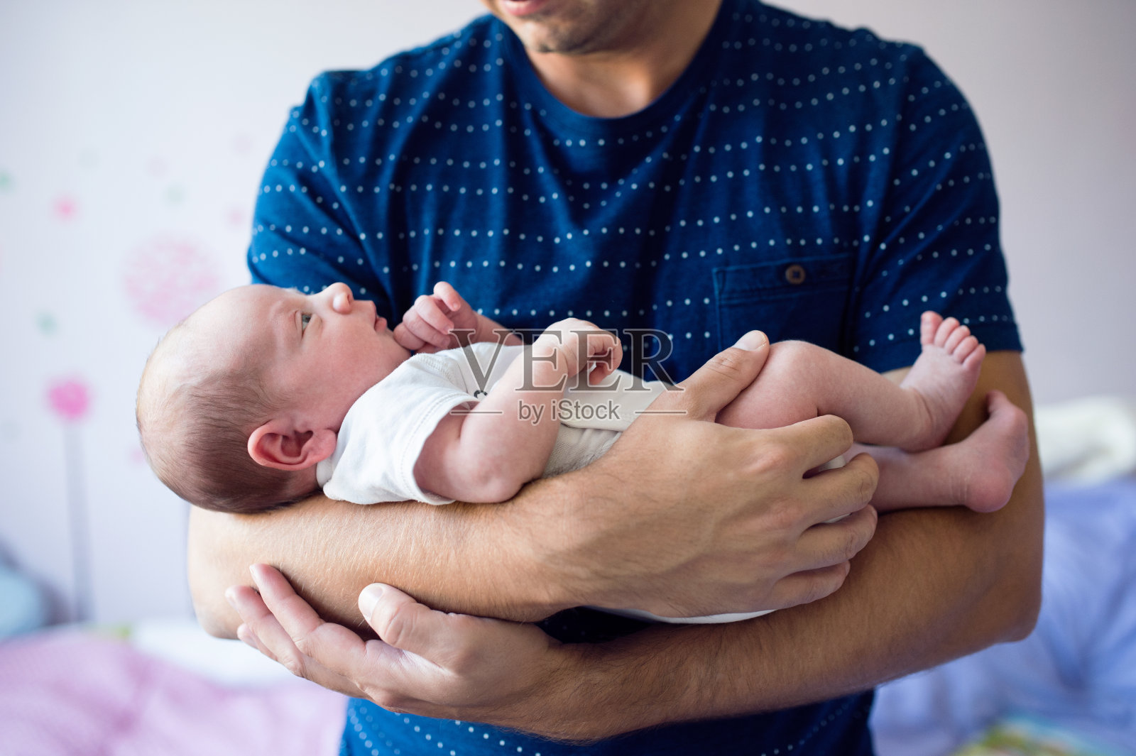 近距离拍摄一位面目全非的父亲抱着他刚出生的儿子照片摄影图片